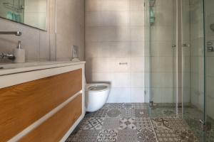a bathroom with a toilet and a glass shower at Seaside Court Retreat By IsrApart in Tel Aviv