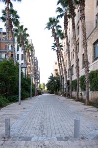 una calle adoquinada con palmeras y edificios en Jaffas Yard By IsrApart en Tel Aviv