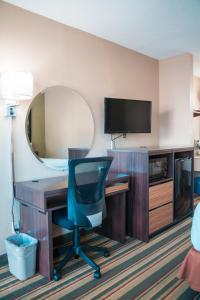 a room with a desk with a chair and a mirror at Super 8 by Wyndham Columbia/Ft. Jackson SC in Columbia