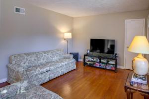 a living room with a couch and a flat screen tv at Cozy Memphis Vacation Rental Near Beale Street! in Memphis