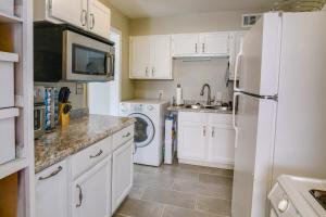 a kitchen with white cabinets and a washer and dryer at Cozy Memphis Vacation Rental Near Beale Street! in Memphis