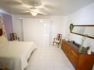 - une chambre avec un lit, une commode et un miroir dans l'établissement Tropical Retreat Stay Aruba, à Oranjestad
