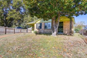 a small house with a tree in the yard at Cozy Memphis Vacation Rental Near Beale Street! in Memphis