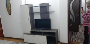 a woman standing in a living room with a tv at Сдаётся квартира , посуточно в центре города in Edineţ