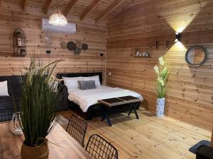 1 dormitorio con 1 cama en una habitación de madera en צימר היעד en Dāliyat el Karmil