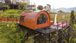 a tree house with a deck on a hill at Glamping The Mountain in Guatapé