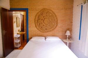 une chambre avec un lit blanc et un mur de briques dans l'établissement Otima casa c Wi Fi 8 min da praia Barequecaba SP, à São Sebastião 26 autres photos