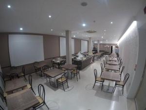 a restaurant with tables and chairs and a white wall at Hotel Laura Beach in Rimini
