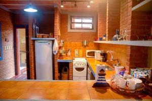 - une cuisine avec un comptoir, une cuisinière et un évier dans l'établissement Otima casa c Wi Fi 8 min da praia Barequecaba SP, à São Sebastião