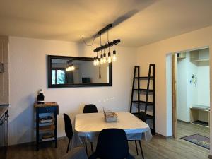 Habitación con mesa con sillas y espejo. en 2,5 pièces à Haute-Nendaz, grande terrasse, piscine, sauna, tennis, en Nendaz