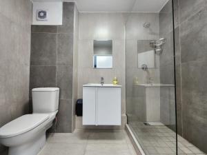 a bathroom with a toilet and a sink and a shower at Penzance by the beach in Durban +11 photos