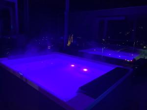 uma piscina com luzes roxas num quarto escuro em Dolomites Alpin Penthouse, 90qm, WLAN, privat Sauna - privat Whirlpool em Mühlbach