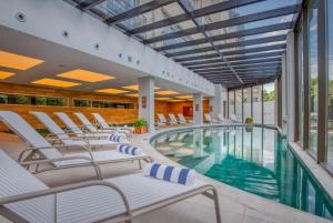 una piscina con sedie a sdraio e una piscina di Suite Quadruplo 7 dias - Wyndham Gramado Termas Resort & Spa a Gramado