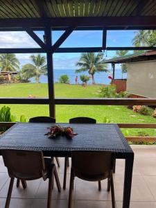 - une table noire avec des chaises et une vue sur l'océan dans l'établissement HEIRAI TAHITI EXPERIENCE, à Vairao