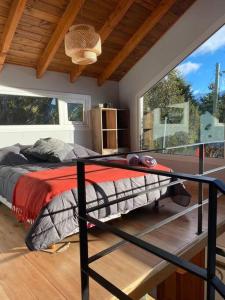 a bedroom with a bed and a large window at Estación Ventana - cabaña al pie del cerro in San Carlos de Bariloche +13 photos
