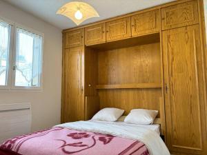 a bedroom with a bed and a wooden cabinet at Appartement Villard-de-Lans, 3 pièces, 6 personnes - FR-1-548-4 in Villard-de-Lans