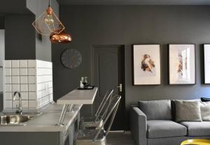 a kitchen with a couch and a clock on the wall at 2 Bdr / Cozy Ap Near Old Town in Bucharest +11 photos