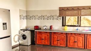 a kitchen with a sink and a washing machine at Villea Frangipani in Mahe
