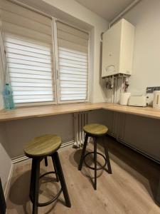 a kitchen with two stools in front of a counter at Luna Apartament NOU zona spital UMF in Târgu-Mureş