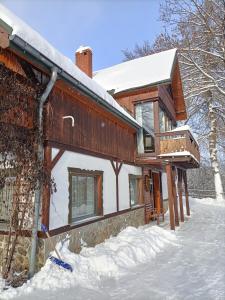 una casa nella neve con una pala da neve di Kurzacka Chata a Szklarska Poręba