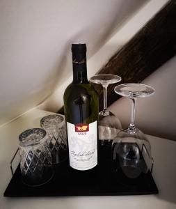 a bottle of wine and two glasses on a shelf at ubytování U NIKY in Hodonín