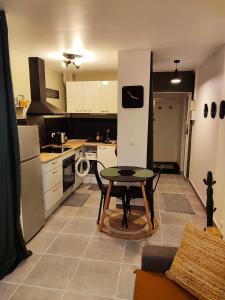 a kitchen with a table and a small table in it at Cosy Studio à proximité de PARIS in Savigny-sur-Orge +3 photos