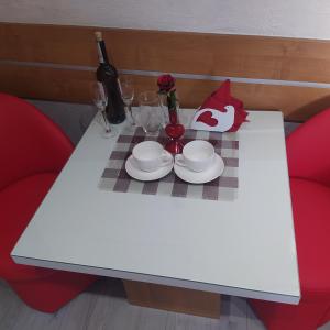 een witte tafel met borden en wijnglazen erop bij Pokoik Walentynka in Gniezno