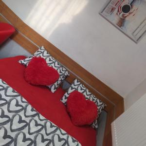 a bed with two pillows with two hearts on it at Pokoik Walentynka in Gniezno