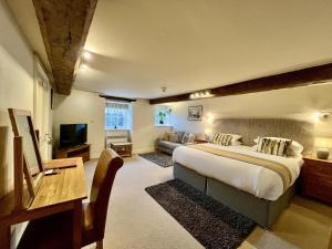 a large bedroom with a bed and a couch at Castle Cottage Inn in Harlech