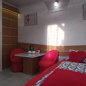 een kamer met een bed en een tafel en stoelen bij Pokoik Walentynka in Gniezno