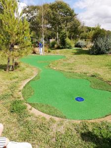 a golfer is standing on a putting green at Vie de famille in Sainte-Cécile-Plage