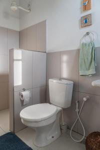 a white bathroom with a toilet and a sink at Casa Boomerang in Marau
