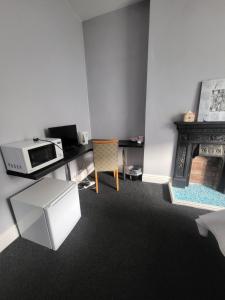 a kitchen with a microwave and a table and a stove at Haya Guest House in Birmingham