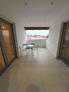 a balcony with a table and chairs in a room at Riga's modern attic in Drama