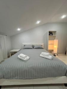 una camera da letto con un grande letto con asciugamani di Riga's modern attic a Drama