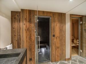 ein Badezimmer mit Holzwänden und einer Glasdusche in der Unterkunft Chalet chaleureux familial avec spa, sauna et proche pistes à Méribel Village. - FR-1-566-24 in Les Allues