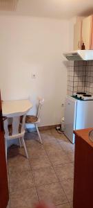 a kitchen with a white table and a table and a table and a refrigerator at Garsonjera in Zagreb