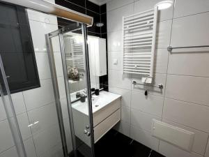 a white bathroom with a sink and a shower at Pink House in Ponta do Sol