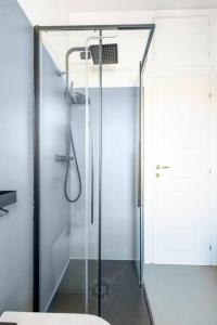 La salle de bains est pourvue d'une douche avec une porte en verre. dans l'établissement Appartamento Milano Infinite Dreams 1 min MM1, à Milan