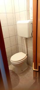 Garsonjera في زغرب: حمام مع مرحاض أبيض في الغرفة