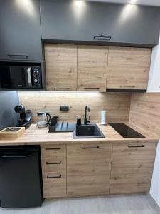 a kitchen with a sink and a microwave at Dux Apartmani - Milmari, Kopaonik in Cajetina