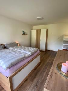 1 dormitorio con 1 cama grande y suelo de madera en Ferienwohnung Happy, en Medebach