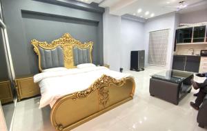 ein Schlafzimmer mit einem Bett mit einem goldenen Rahmen in der Unterkunft Citi Hotel Apartments in Jhelum