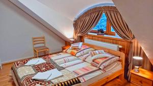 een slaapkamer met een groot bed en een raam bij Dębowa Dziupla in Białowieża