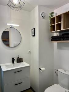 Baño blanco con lavabo y espejo en Appartement neuf à 400 m des remontées avec Sauna, en La Chapelle-dʼAbondance