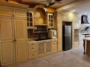 a large kitchen with wooden cabinets and a refrigerator at Prime Villa in Kuala Lumpur