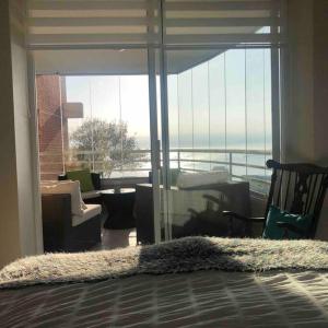 una sala de estar con una gran puerta de cristal con vistas en Algarrobo Punta Fraile Hermosa vista a la bahia de Algarrobo, en Algarrobo