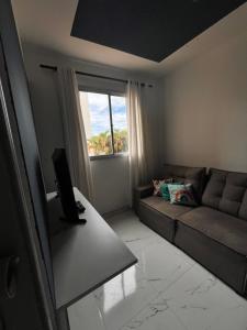 a living room with a couch and a window at Aptos 1 quarto Ar Saraiva in Uberlândia