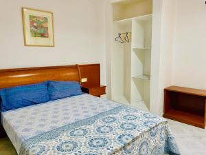 a bedroom with a bed with a blue and white comforter at Nouadhibou Guest House in Nouadhibou