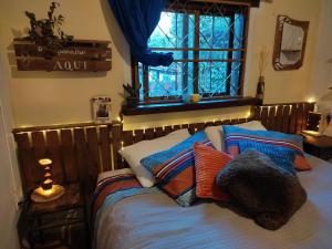 a bedroom with a bed with pillows and a window at Casa Paradise - charmechapad a in Alto Paraíso de Goiás